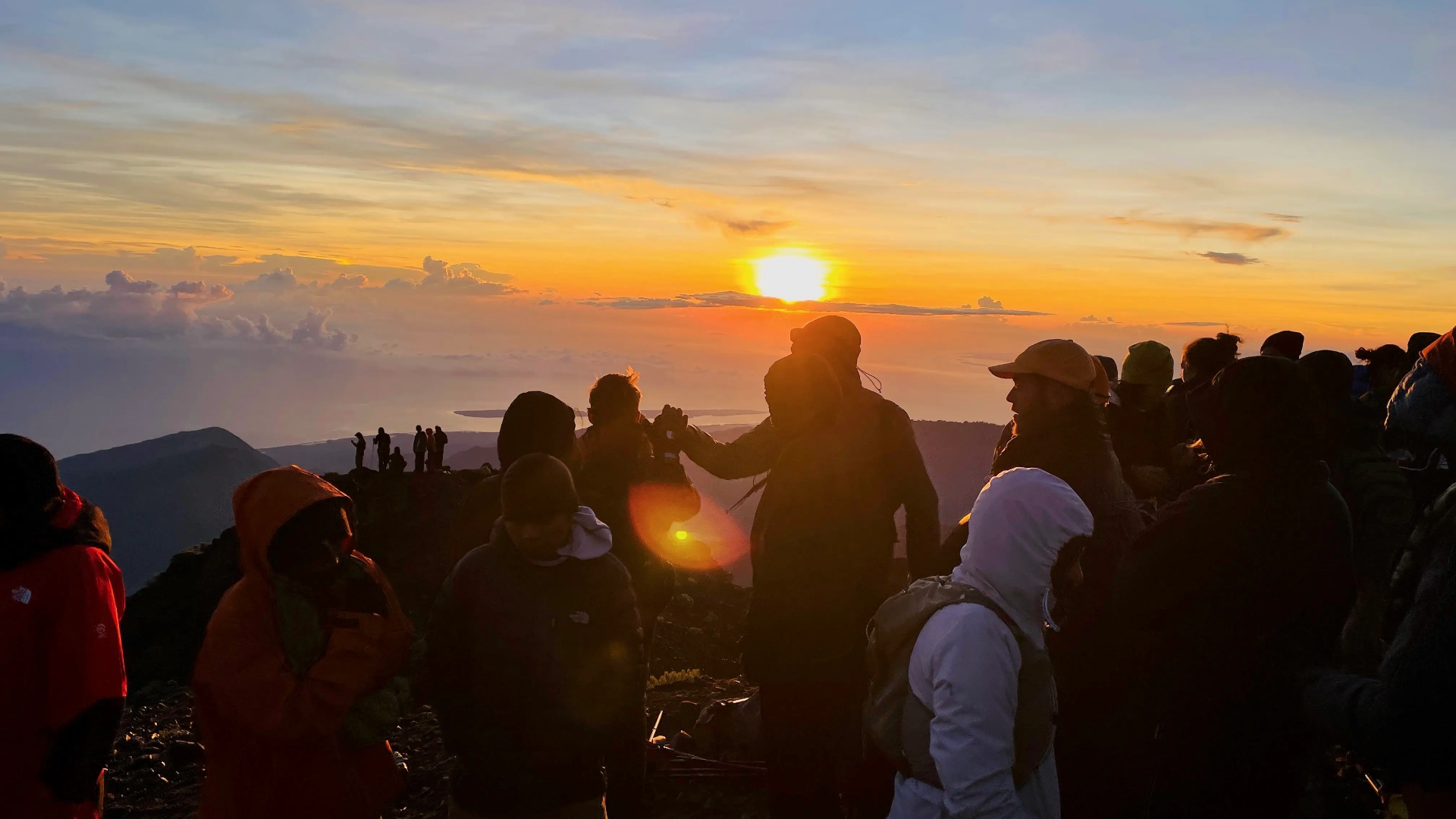 Trekkers gathered at the summit watching sunrise over the clouds